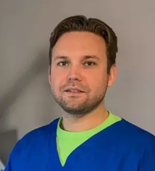 A man wearing a blue shirt and green shirt receiving TMS Therapy in Utah or Salt Lake City.