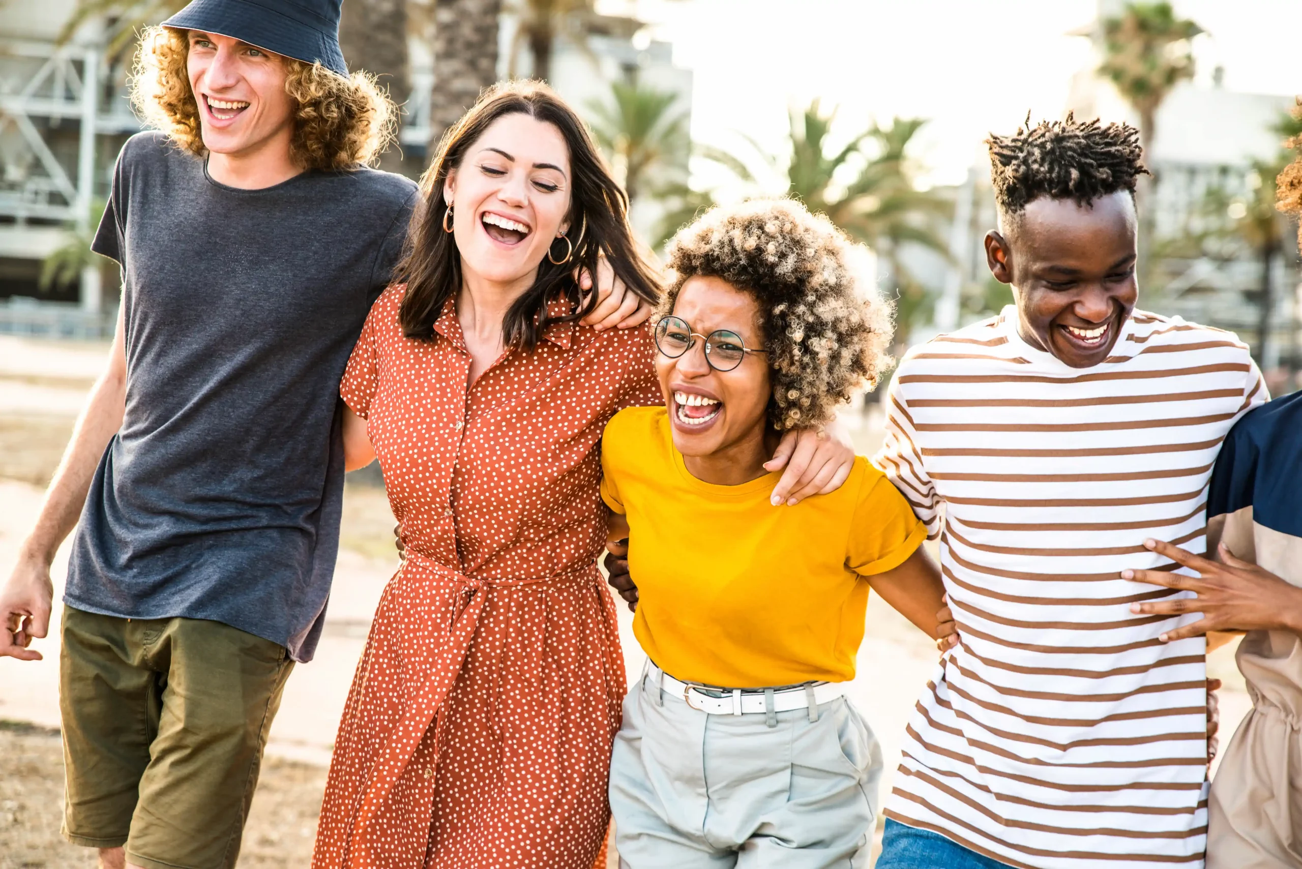 A group of friends laughing together at the beach while undergoing Transcranial Magnetic Stimulation (TMS) Therapy in Utah.